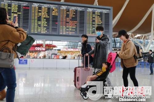 旅客帶著孩子前往辦票柜臺(tái)辦理登機(jī)手續(xù)?！∫罅⑶?攝