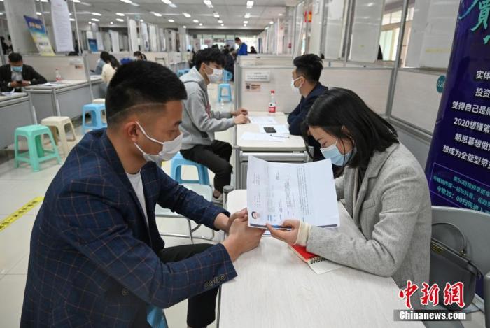 4月14日，招聘者在查看求職者簡歷。<a target='_blank'  data-cke-saved- >中新社</a>記者 王剛 攝