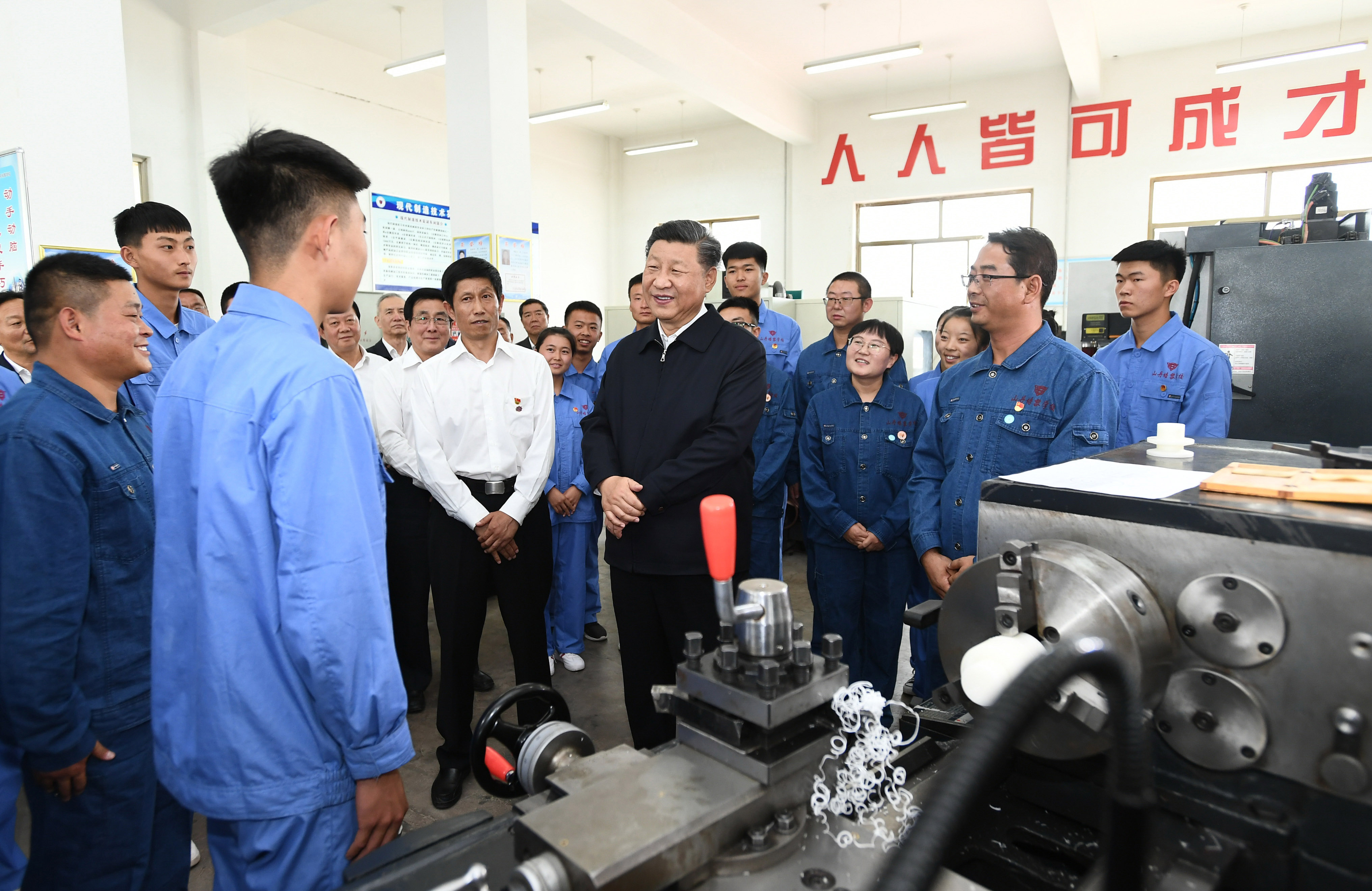 2019年8月20日，習(xí)近平在甘肅省張掖市山丹培黎學(xué)校現(xiàn)代制造技術(shù)實(shí)訓(xùn)室，觀看職業(yè)技能實(shí)訓(xùn)，同師生親切交流。