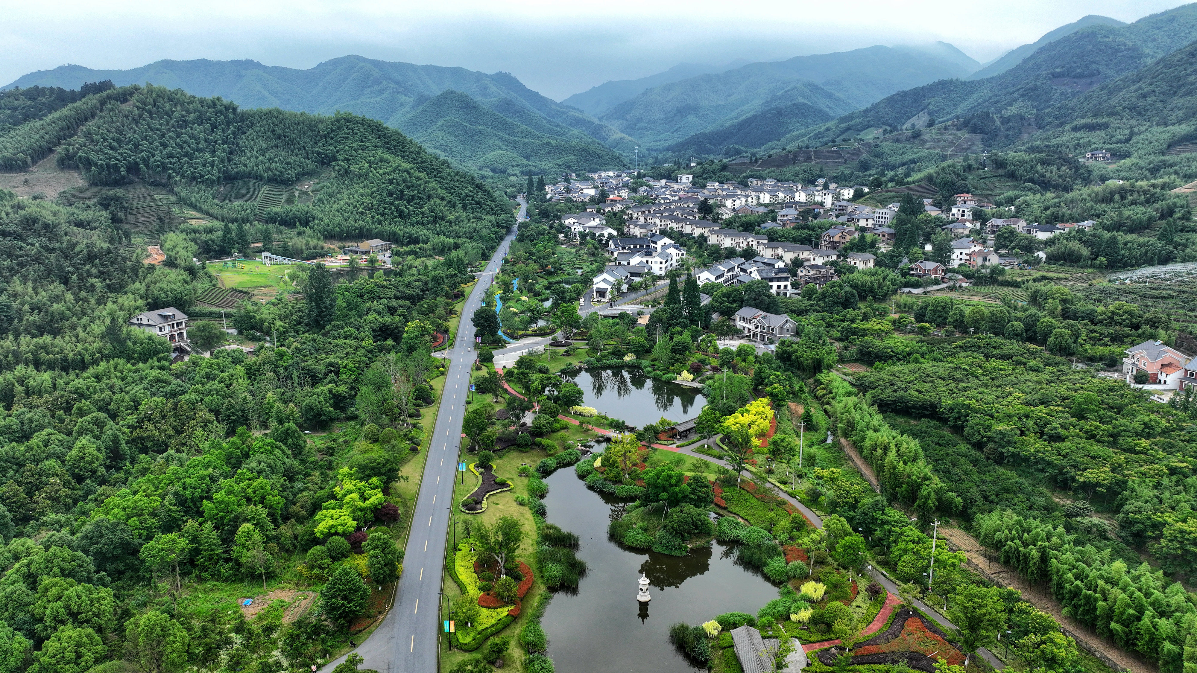 2023年6月6日，杭州余杭區(qū)徑山鎮(zhèn)鄉(xiāng)村，生態(tài)碧水、沿路花海與村莊農(nóng)房相映成趣，構(gòu)成一幅美麗的山水田園畫。