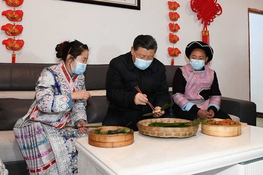 2021年2月3日下午，習(xí)近平在貴州畢節(jié)市黔西縣新仁苗族鄉(xiāng)化屋村苗族村民趙玉學(xué)家，同一家人邊聊家常邊制作當(dāng)?shù)貍鹘y(tǒng)節(jié)日食品黃粑。新華社記者 李學(xué)仁 攝