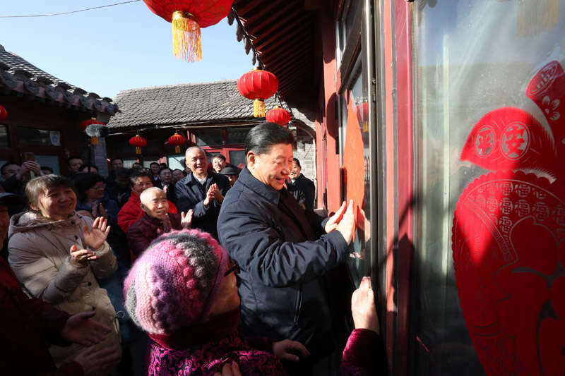 2019年2月1日上午，習(xí)近平在北京前門東區(qū)草廠四條胡同32號院，高興地拿起一幅“?！弊?，親自貼到門上，給這里的老街坊們拜年。新華社記者 鞠鵬 攝
